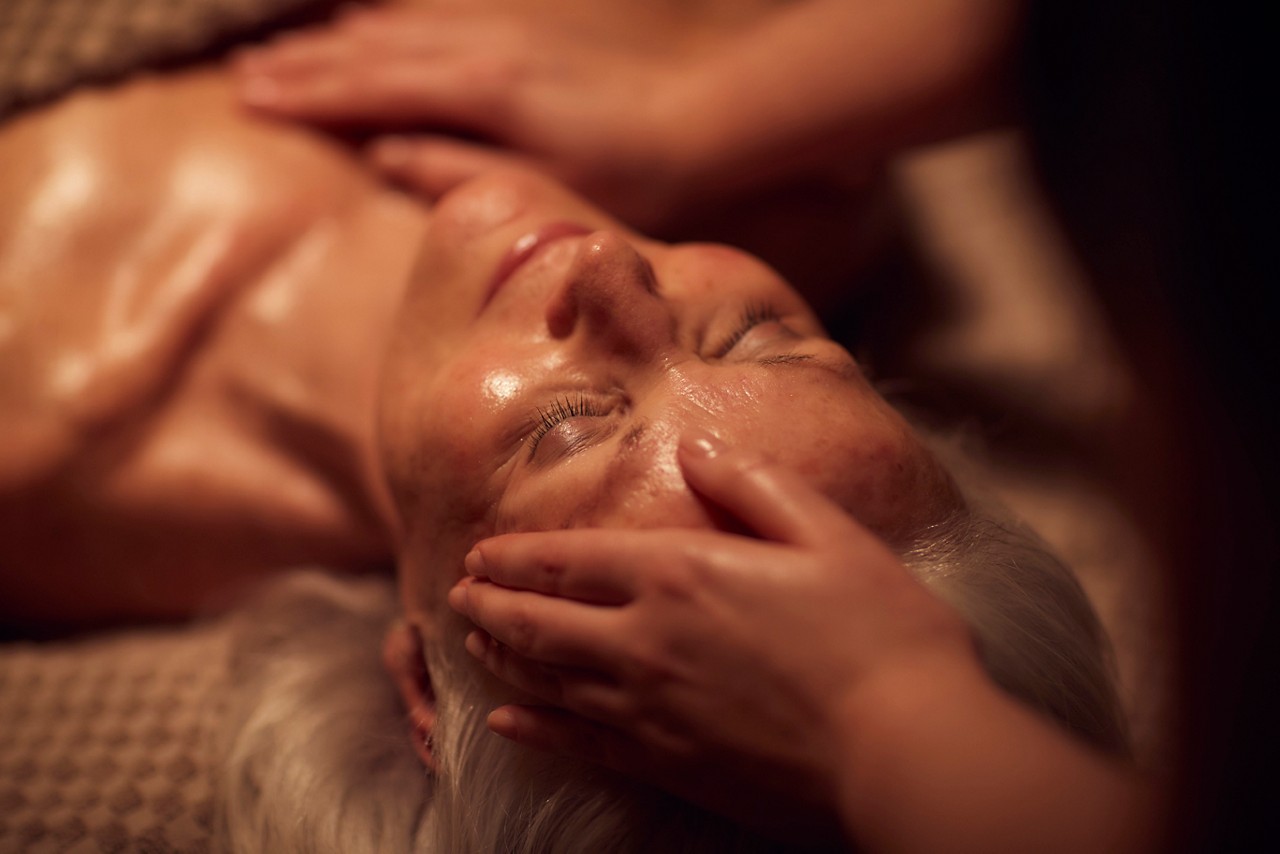 Spa therapist giving a woman a facial treatment.