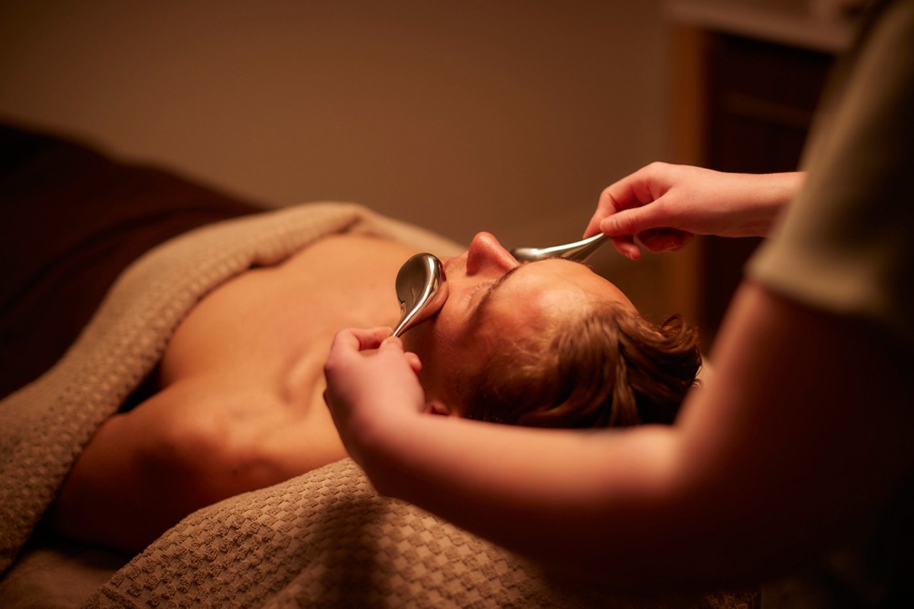 Woman having a facial with little brushes.