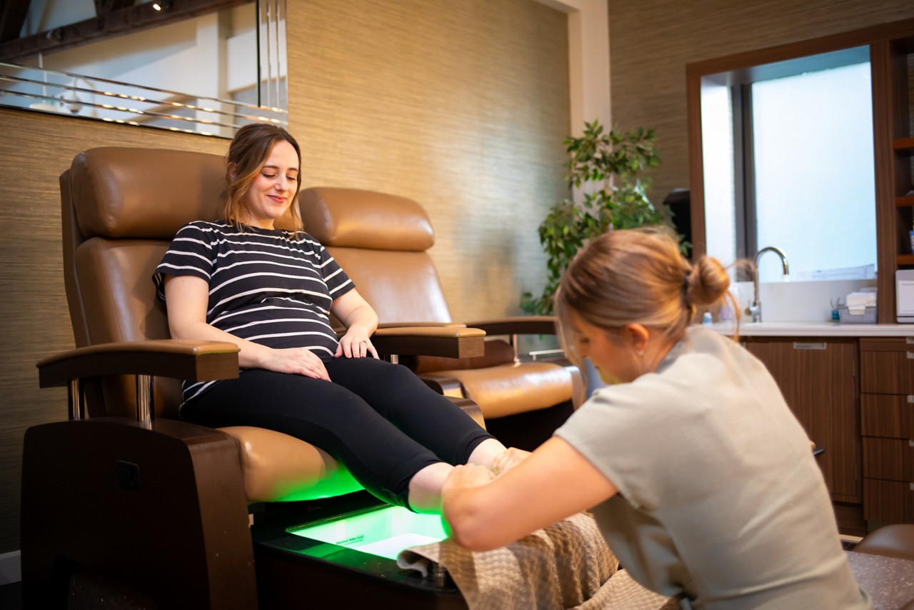 A lady having a pedicure in a massage chair.