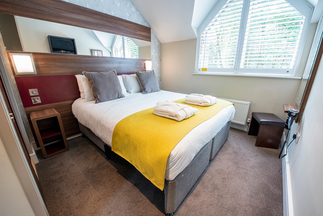 Double bed with neatly folded spa robes in a Spa Break apartment.