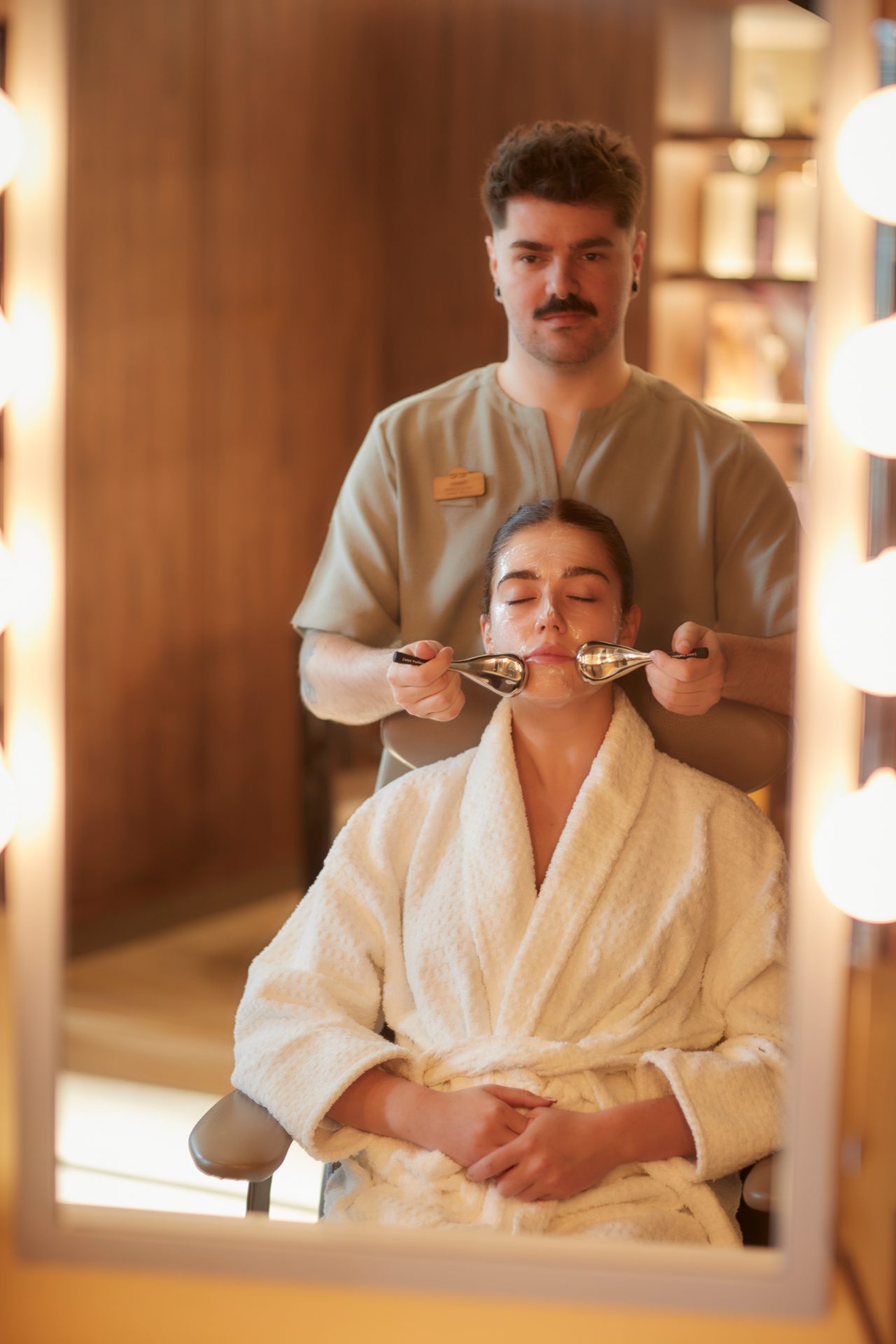 Woman having a facial with smooth metal discs.